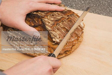 Woman Cutting Loaf of Bread
