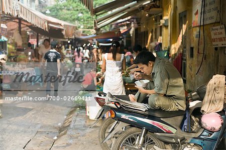 Man on Parked Motorcycle Eating Rice, Old Quarter, Hanoi, Vietnam