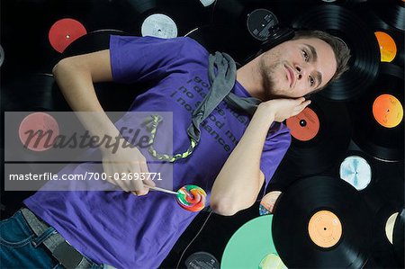 Man Lying on Pile of Records