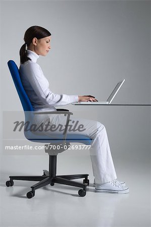 https://image1.masterfile.com/getImage/700-02693777em-woman-sitting-at-a-desk-in-an-ergonomic.jpg