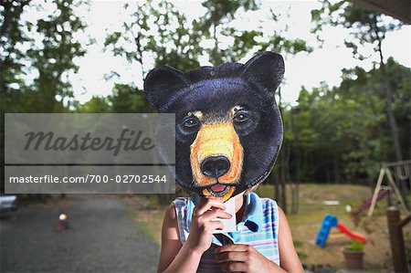 Little Girl Wearing Animal Mask in Backyard