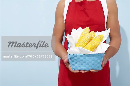 Woman Holding Basket of Corn on the Cob