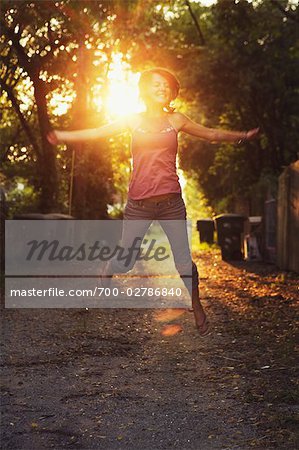 Woman Outdoors Jumping Up in the Air at Dusk, Savannah, Georgia, USA