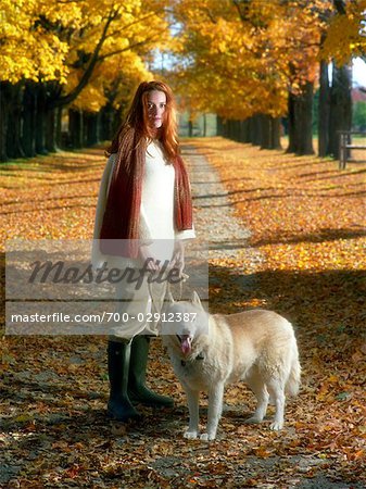 Portrait of Woman with Dog in Park in Autumn