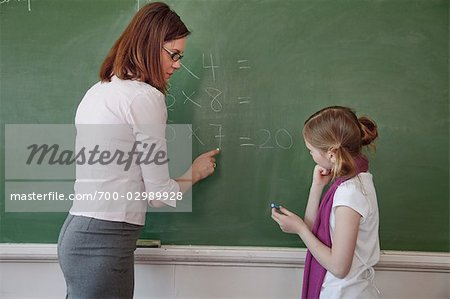 Teacher and Student Doing Math on the Chalkboard