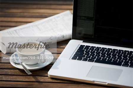 Laptop Computer, Newspaper and a Cup of Coffee