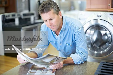 Man in Appliance Store Reading Brochures