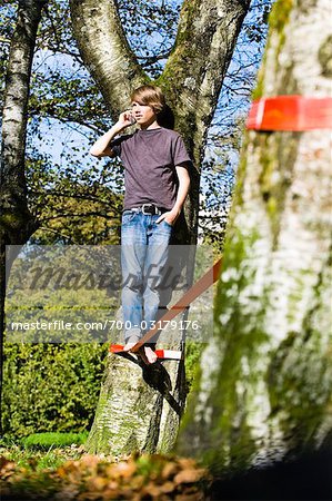 Boy Slacklining and Talking on Cellular Telephone