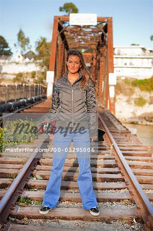 Woman on Railroad Tracks Posing With Her Skateboard, Santa Cruz, California, USA