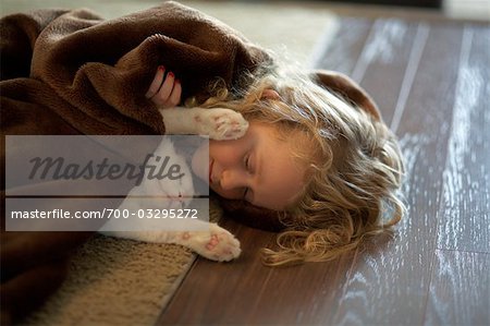 Little Girl and Ragdoll Cat Asleep Together on the Floor Little Girl and Ragdoll Cat Asleep Together on the Floor