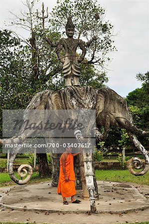 Monk in Front of Statue at Buddha Park, Vientiane Province, Laos