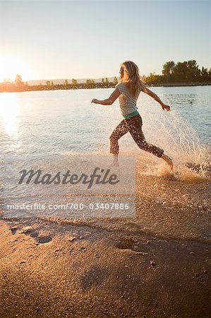 Woman Running through Water in River, Oregon, USA