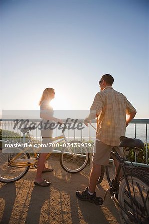 Man and Woman Riding Cruiser Bikes by the Pacific Ocean in Santa Cruz, California, USA