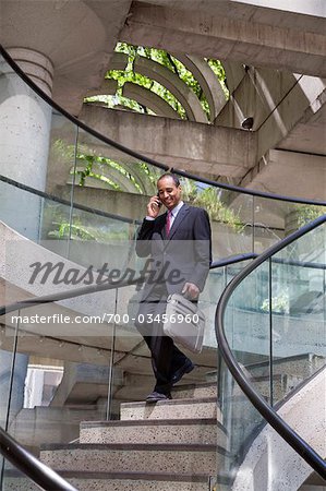 Businessman Descending Stairs while Talking on Cell Phone