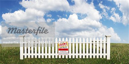 White Picket Fence with Sold Sign in Open Field