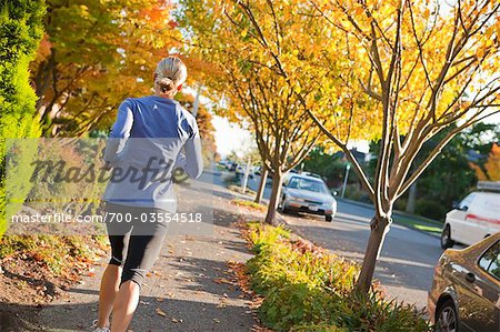 Woman Running on Sidewalk in Autumn, Seattle, Washington, USA