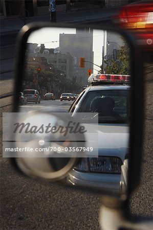 View of Police Car in Side View Mirror, Toronto, Ontario, Canada