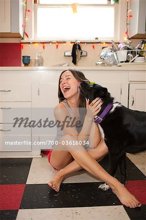 Woman Playing With Dog in Kitchen Woman Playing With Dog in Kitchen