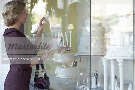 Woman Looking at Wedding Cakes through Shop Window