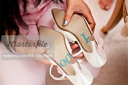 Woman Holding Shoes with "I Do" on Soles