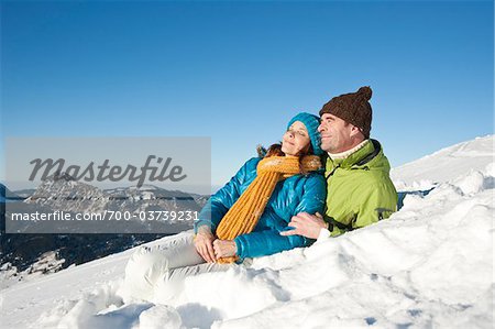 Couple Lying in Snow on Mountain