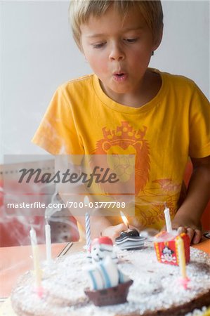 Boy Blowing out Candles on Birthday Cake