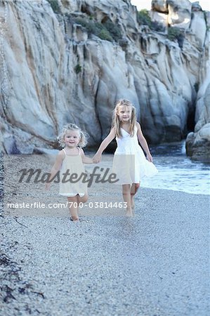 Sisters Holding Hands on Beach