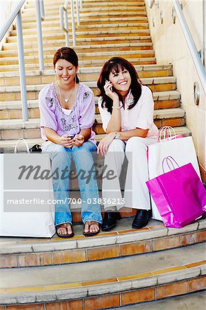 Mother and Daughter Sitting on Steps with Shopping Bags