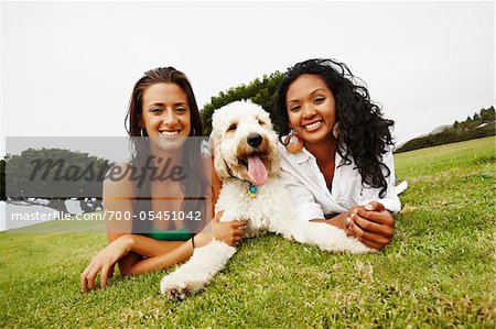 Two Women Lying on Ground with Dog