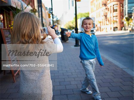 Girl Taking Photograph of Boy, Front Street, Toronto, Ontario, Canada