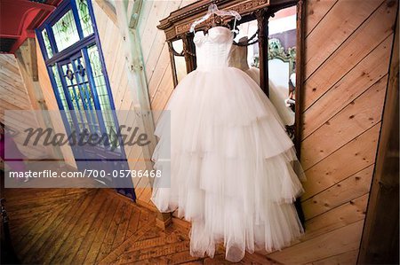 Wedding Gown Hanging in front of Mirror