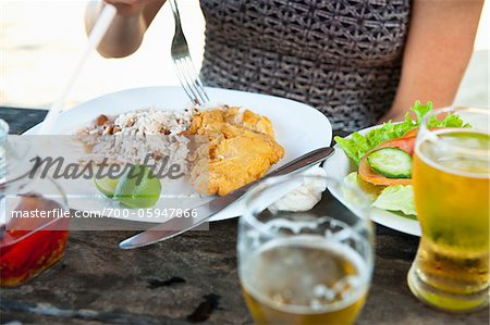 Woman Eating Meal of Fried Fish, Rice and Beans, and Salad at Beachside Cafe, near Paraty, Rio de Janeiro, Brazil
