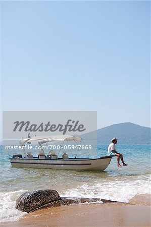 Man Sitting on Boat, near Paraty, Rio de Janeiro, Brazil