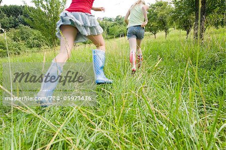 Two Girls Running in Field