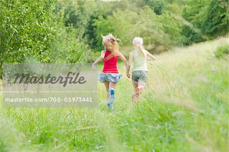 Two Girls Running in Field