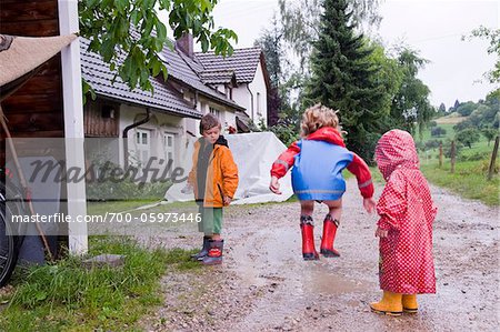 Three Children Playing in Puddles