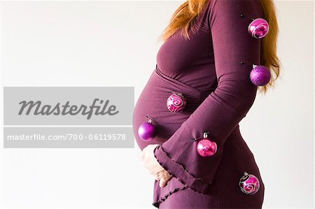 Pregnant Woman Decorated with Christmas Balls in Studio