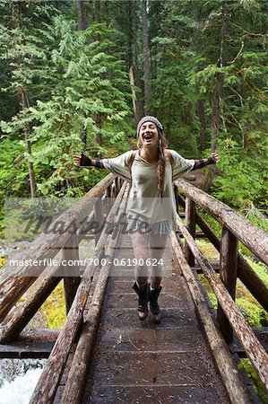 Young Woman with Open Arms Crossing Bridge Young Woman with Open Arms Crossing Bridge