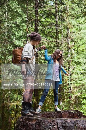 Two Teenagers Playing on Tree Trunk
