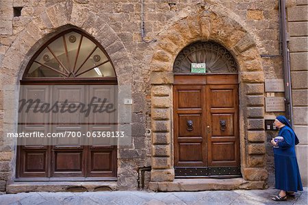 Nun Walking by Doors, Volterra, Tuscany, Italy