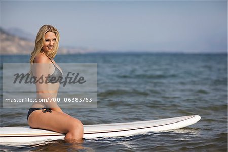 Surfer Sitting on Surfboard
