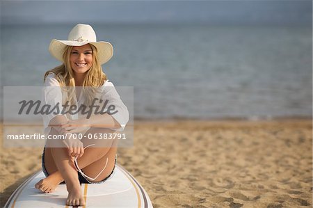 Portrait of Woman Sitting on Surfboard