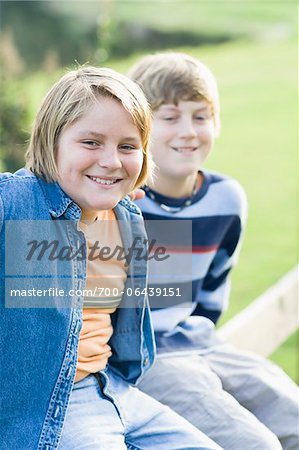 Portrait of Two Boys Sitting Outdoors on Fence