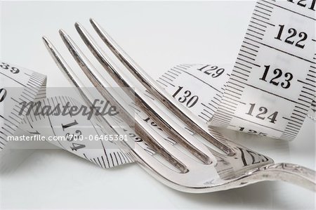 Close-Up of Fork Lying on top of Measuring Tape