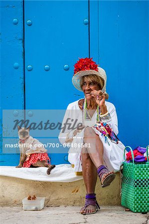 Woman Smoking Cigar and Sitting on Curb with Cat Wearing Costume, Old Havana, Havana, Cuba