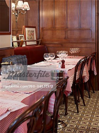 Empty tables with wine glasses and place settings, inside restaurant cafe, Fontaine de Mars, Paris, France