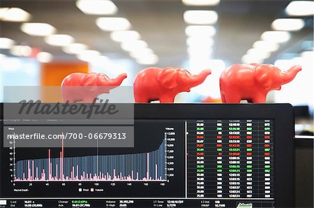 view of computer monitor with financial data and toy elephants