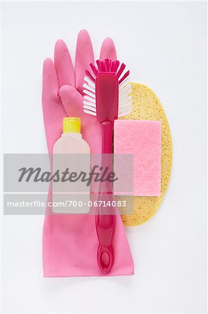 still life of cleaning products including dish scrub brush, sponges, plasic bottle, and pink rubber glove