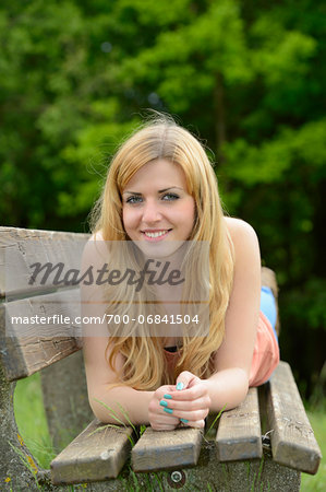 Young woman lying on a bench outdoors, Germany