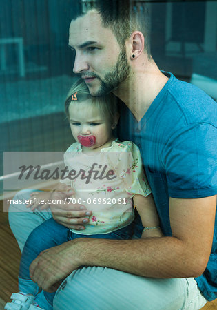 Baby Girl sitting on Father's Lap at Home, Mannheim, Baden-Wurttemberg, Germany